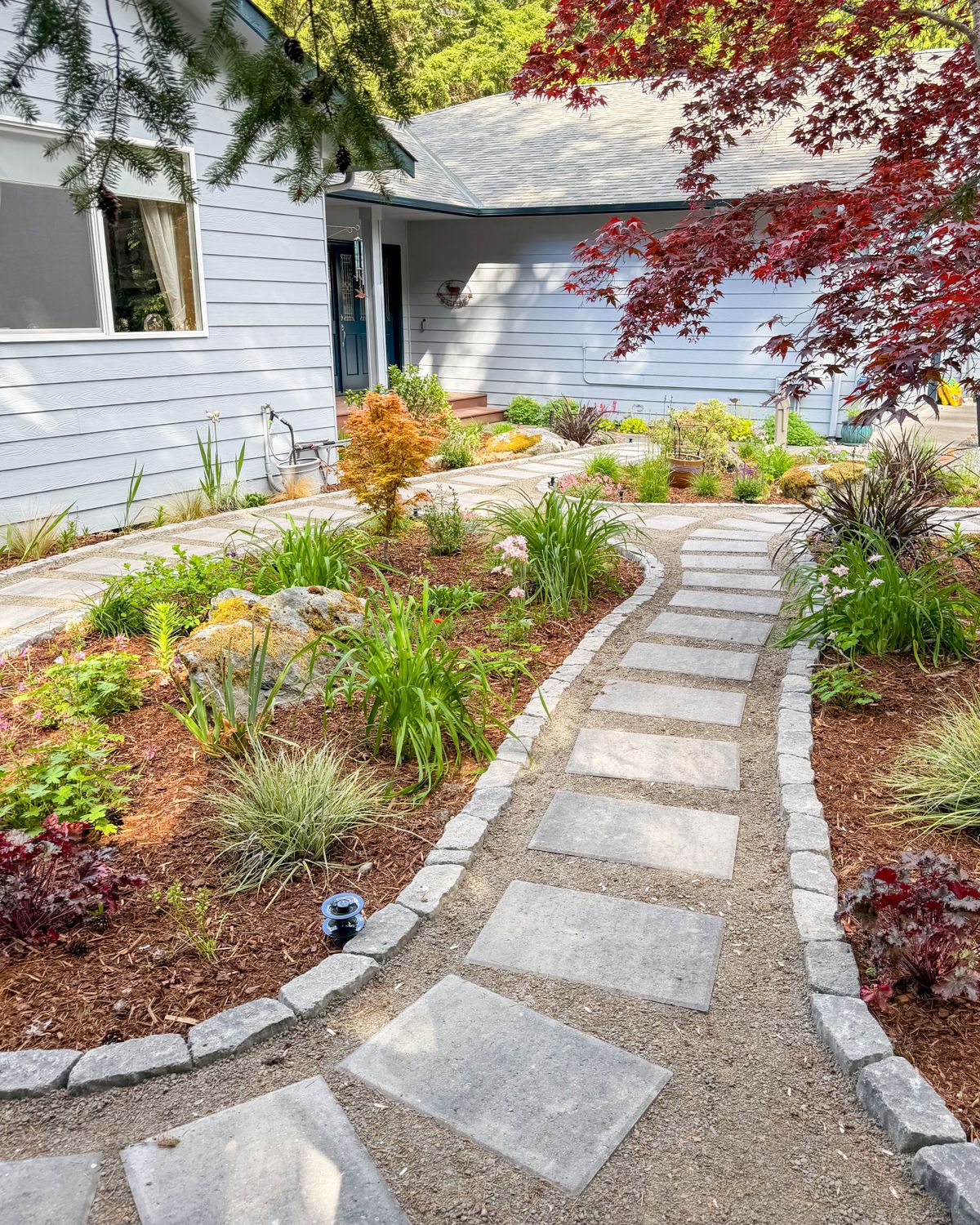 Stepping-stone garden path with block edging through new planting beds